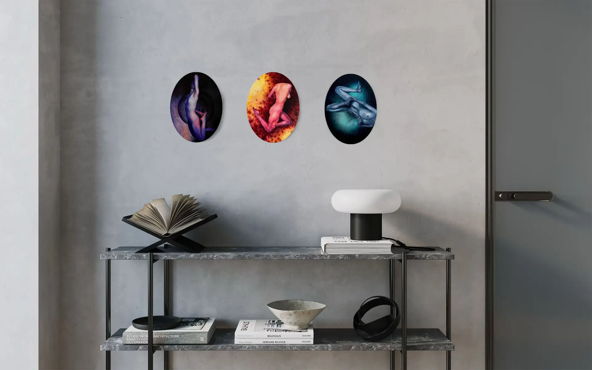 Three oval paintings of human nudes in expressive tones, decorating a minimalist interior wall