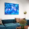 Blue female nude painting displayed above a turquoise sofa in a modern living room.