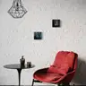 Modern nude artworks in dark tones hanging on a white brick wall