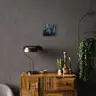 Female nude in cool tones on a gray wall in an elegant, dark-toned interior