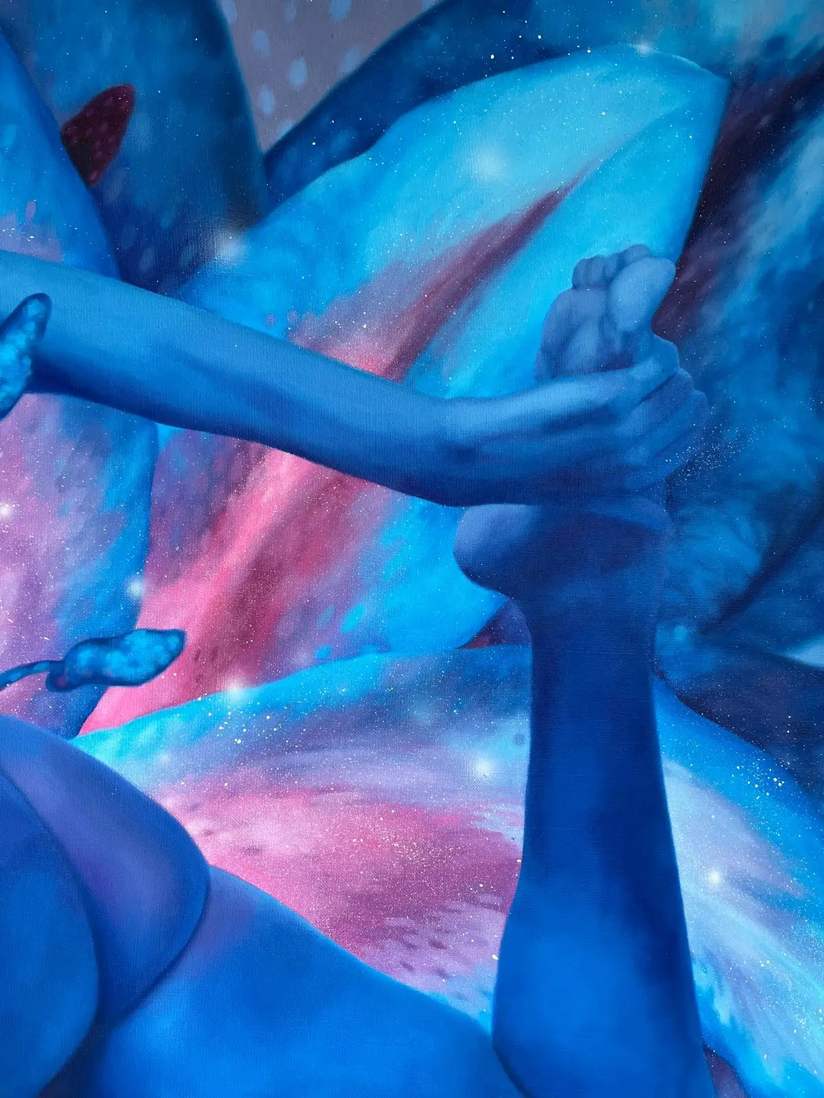 Detail of a blue figurative painting with intertwined hands and feet against cosmic flower petals.