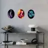 Three colorful oval paintings of artistic nudes displayed in a modern interior