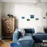 Living room visualization with a blue sofa and four female nude paintings hanging on a light wall
