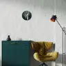 A modern interior with a green cabinet and a mustard-colored armchair, with a round painting of an abstract male nude figure hanging on the wall