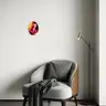 Oval painting of a female nude in red and orange tones on a bright wall