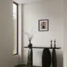 Modern interior with a black console and an abstract-style oil painting on the wall
