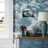 Pastel-toned painting with dynamic nudes on a floral wallpaper in a classic interior