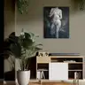 Contemporary female nude painting on the wall in a living room with a wooden sideboard and green plant, elegant interior decoration